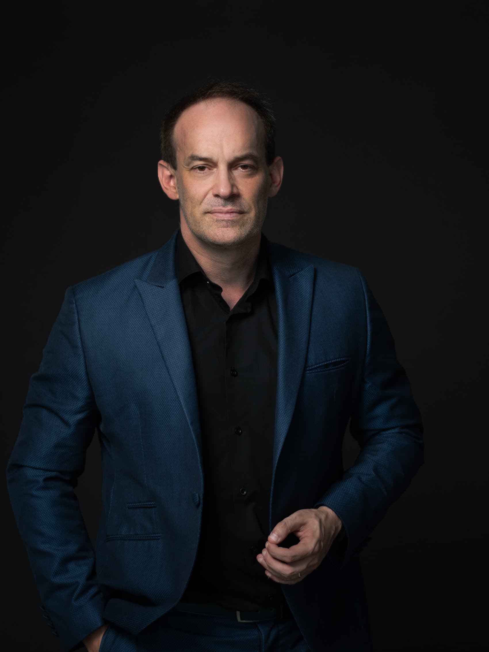 Michael Backes against a dark studio wall